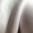 Detailní pohled na jemnou, hladce tkanou textilii s jemnou strukturou a lehkým leskem.