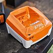 Nabíječka na baterie STIHL AL 301 určená pro dobíjení akumulátorových článků, umístěná na pracovní desce.