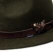 Zelený filcový klobouk s hnědým sametovým páskem ozdobeným peřím a malou cedulkou s nápisem Sympatex.