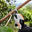 Elektrické zahradnické nůžky STIHL zastřihávající tenkou větev stromu.