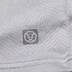 Detailní pohled na jemnou tkaninu s plstěným logem ve tvaru stylizovaného zvířecího obličeje uvnitř kruhu.