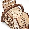 Detail dřevěného mechanického modelu s rukojetí a ozubenými částmi připomínajícími starý přenosný přístroj nebo stroj.
